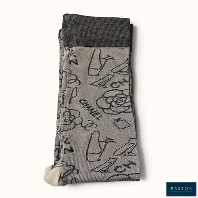 Les chaussettes sont grises, avec des motifs noirs et blancs.