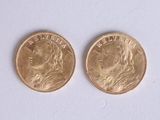 deux pièces d'or posées côte à côte sur une surface blanche