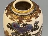 a vase with a floral design on it sitting on a table