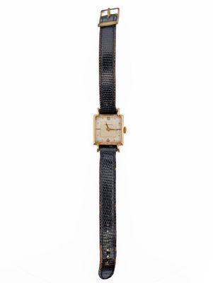 an image of a gold and black watch on a white background