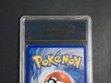 the pokemon card is in a plastic holder on a table