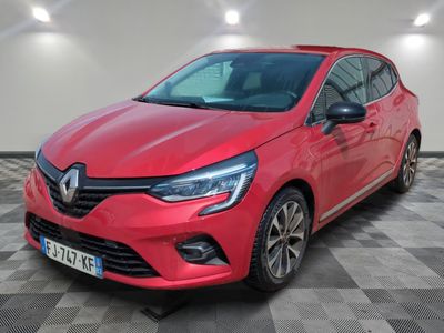 une voiture rouge garée dans un garage au sol en damier