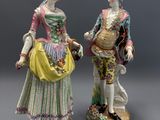 deux figurines représentant un homme et une femme vêtus de costumes d'époque