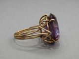 a close up of a ring with a purple stone in it