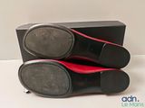 pair of black and red shoes sitting on top of a black box