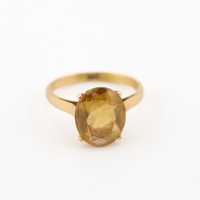 un gros plan d'une bague en or jaune sertie d'une citrine de taille ovale
