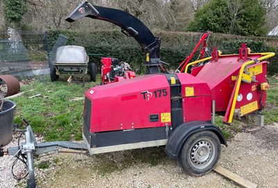 une voiture rouge garée à côté d'un barbecue