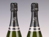 two bottles of champagne sitting next to each other on top of a table