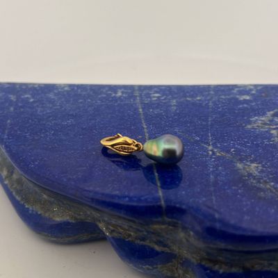 blue stone with a gold ring and a pearl on it