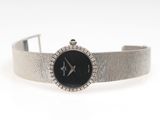 an image of a woman ' s wrist watch with a black dial