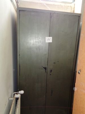 une porte métallique dans une pièce où se trouve un radiateur au sol