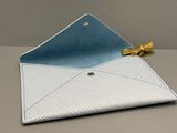 un gros plan d'une enveloppe bleue et blanche posée sur une table