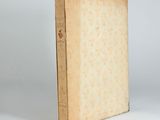 an old book sitting on top of a white table next to a white wall
