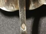 a silver spoon and a fork on a black cloth