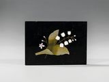une carte noire et dorée ornée de fleurs blanches