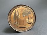 an image of a gold plate with a picture of a house and trees