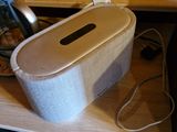 a white speaker sitting on top of a wooden table