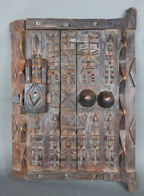 une vieille porte en bois avec des poignées en métal sur fond gris
