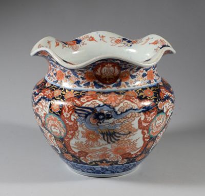 an orange and blue vase with a bird on it