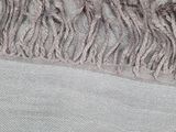 a close up of a blanket with fringes on it