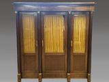 une armoire en bois à deux portes, surmontée d'un miroir