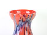 a red and blue vase sitting on a white surface