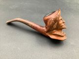 a pipe with a man ' s face on it on a table