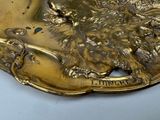 a gold plate with a picture of a lion on it