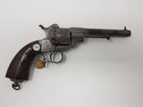 un vieux revolver avec une poignée en bois sur une surface blanche