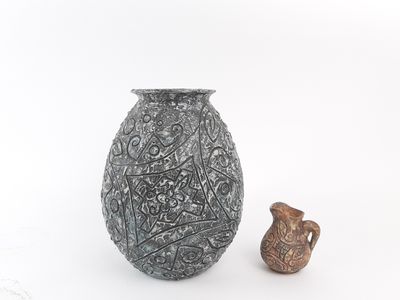 two vases sitting next to each other on a white surface