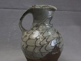 a brown and white vase sitting on a gray surface