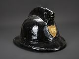 a black fireman ' s helmet with a gold badge on it