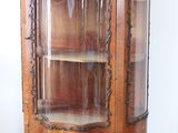 a wooden cabinet with a glass door in the corner of the room
