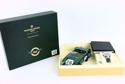 une image représentant une voiture verte dans une boîte, à côté d'un briquet