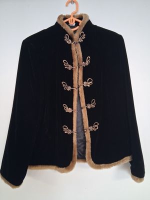 veste en velours noir avec des garnitures dorées et un col doublé de fourrure