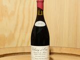 une bouteille de vin posée sur un tonneau