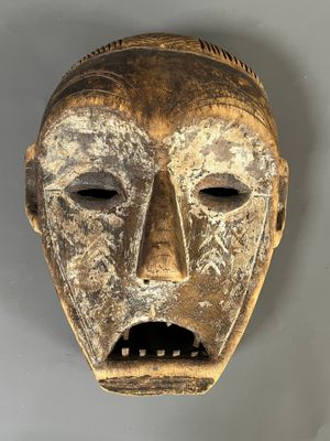 gros plan d'un masque en bois sur une surface blanche
