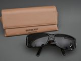 Lunettes de soleil Burberry noires avec étui, sur fond gris