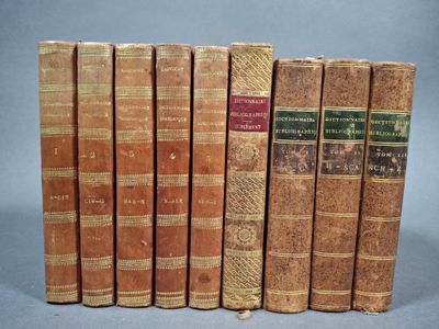 plusieurs vieux livres sont alignés sur une surface grise