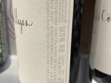 three bottles of wine are lined up on a table