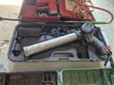 une boîte à outils contenant des outils, posée sur le sol