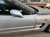 a silver car parked in a garage with other cars in the background