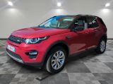 the red land rover is parked in a large room