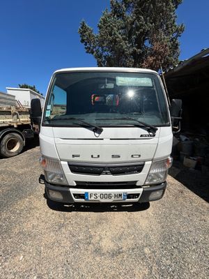 un camion blanc garé sur un parking à côté d'un immeuble