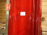 a red shower curtain hanging from a pole in a room