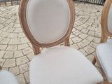 three wooden chairs sitting on a brick patio next to a gate