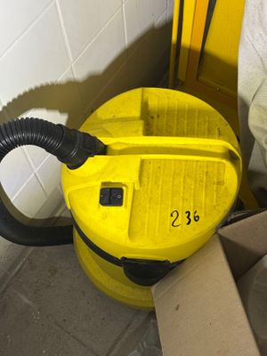 a yellow vacuum cleaner sitting on the floor next to a cardboard box