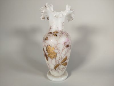un vase blanc orné d'un motif rose et doré