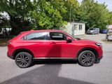 the red suv is parked on the street in front of a house