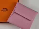 purple leather wallet with orange box and logo on it